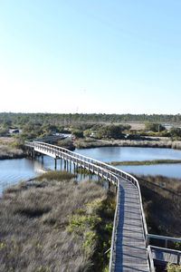 Bridge over river against clear blue sky