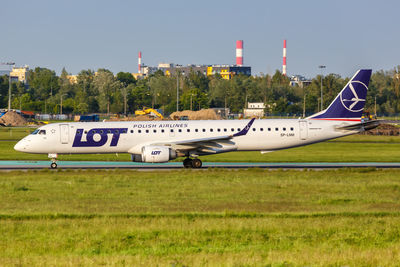 Airplane on airport runway against sky