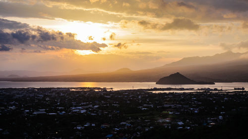 Panoramic view of sea and cityscape against sky during sunset