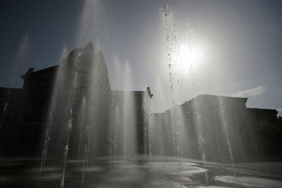 Water splashing on fountain against buildings