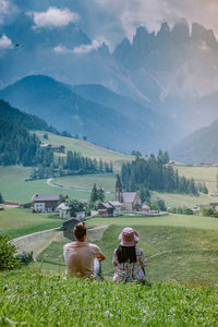 Rear view of women on field against mountains