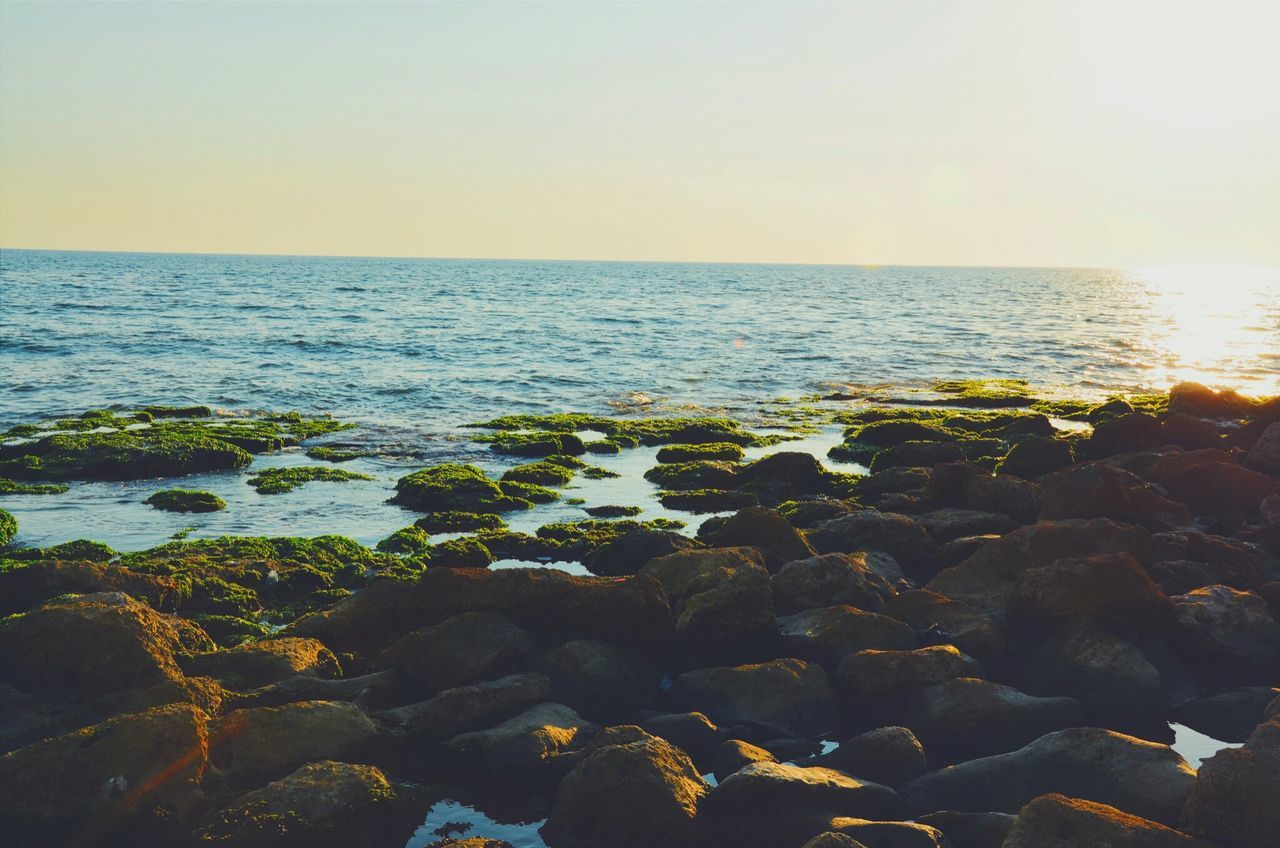 sea, water, horizon over water, clear sky, scenics, tranquil scene, tranquility, beauty in nature, beach, sun, nature, copy space, sunset, rock - object, shore, idyllic, sky, sunlight, reflection, remote