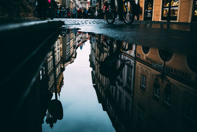 Reflection of buildings in puddle on canal