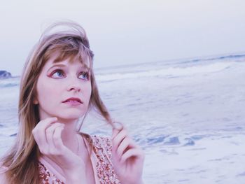 Portrait of beautiful woman on beach against sea