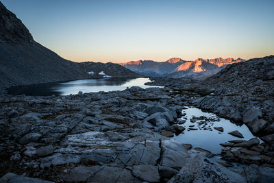 Scenic view of river amidst snowcapped mountains against sky during sunset