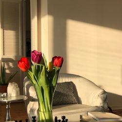 Close-up of red tulips in vase on table at home