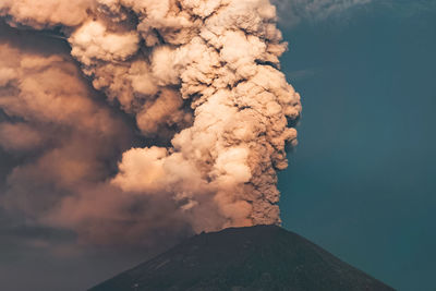 Smoke emitting from volcanic mountain against sky