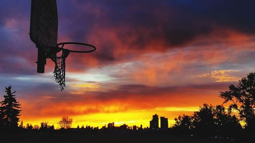 Low angle view of basketball hoop against sky during sunset