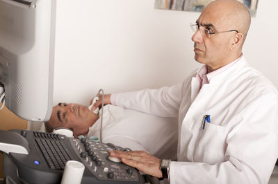 Radiologist examining carotid with ultraschall