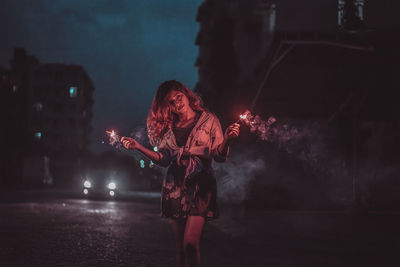 Woman holding umbrella at night