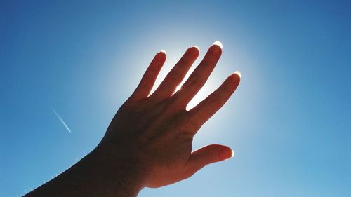 Close-up of hand against clear blue sky