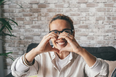 Portrait of smiling woman making heart shape