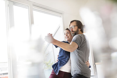 Playful couple dancing at home