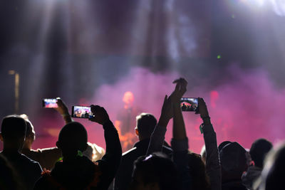 Group of people photographing at music concert