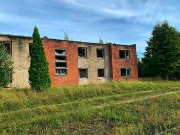 Abandoned house on field against sky