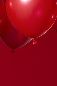 Low angle view of red balloons flying