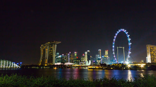 Illuminated ferris wheel in city at night