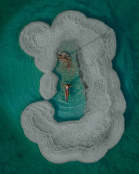 Aerial view of woman floating on sea