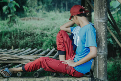 Side view of senior man sitting on land