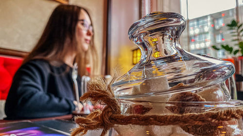 Midsection of woman in glass on table