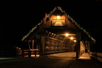 Illuminated bridge against sky at night