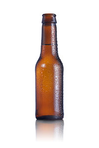 Close-up of wet glass bottle against white background