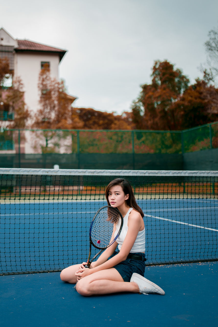 real people, one person, young adult, lifestyles, sitting, young women, leisure activity, looking at camera, portrait, women, day, sport, nature, casual clothing, front view, adult, full length, focus on foreground, outdoors, hairstyle, beautiful woman, swimming pool