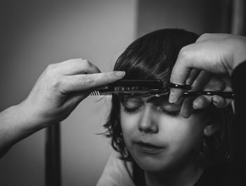 Close-up portrait of a boy having hair cut