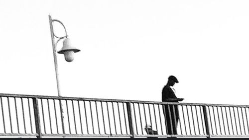 Low angle view of woman standing on railing