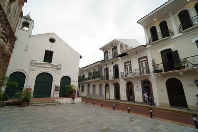 Street amidst buildings against sky in city