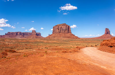 Rock formations on landscape against blue sky