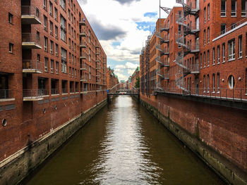 Bridge over river in city against sky