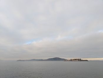 Scenic view of sea and mountains against sky