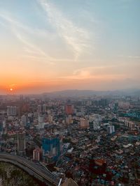 High angle view of illuminated cityscape against sky during sunset