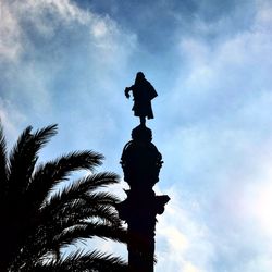 Low angle view of silhouette statue against sky