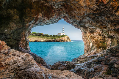 Lighthouse by sea against sky