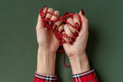 Close-up of woman hand holding strawberry over white background