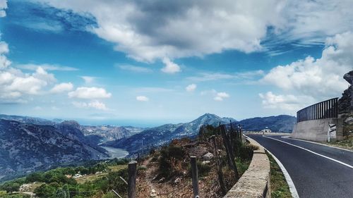 Road leading towards mountains against sky