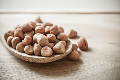 Close-up of hazelnuts with spoon on wooden table