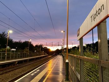 Railroad tracks against sky at sunset