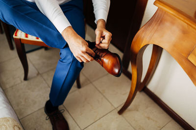 Low section of man holding food on floor at home