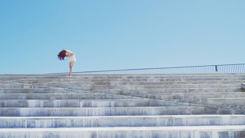 Full length of woman standing on steps