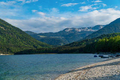 Scenic view of lake by mountains against sky