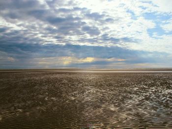 Scenic view of sea against cloudy sky