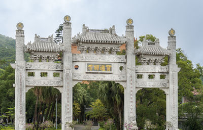 Gate in the ngong ping village with tian tan big buddha in the dstance on lantau island, hong kong