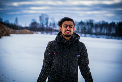 Portrait of young man standing in snow