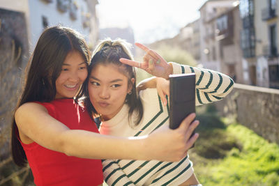 Portrait of smiling young woman using mobile phone