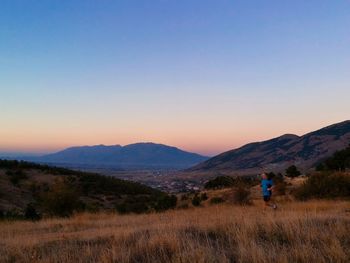 Man with bicycle on mountain against clear sky