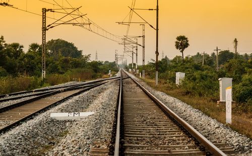 Railroad tracks by trees against sky