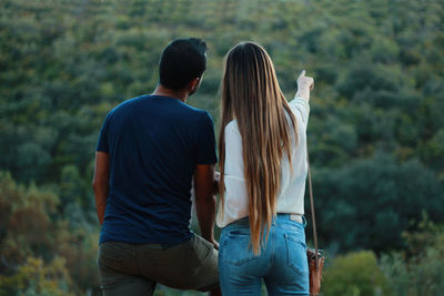 Rear view of couple standing in forest